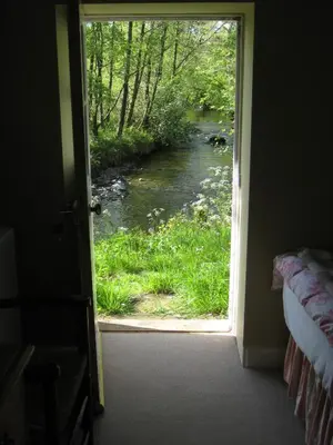a door leading into a room with a view of a river at Riverside House in Thornhill