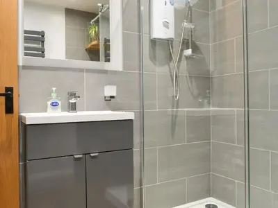 a bathroom with a shower and a sink at Bumble Cottage in Cockermouth