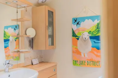 a bathroom with a sink and a painting of a sheep at Slater Bob's Coppermines Valley in Coniston