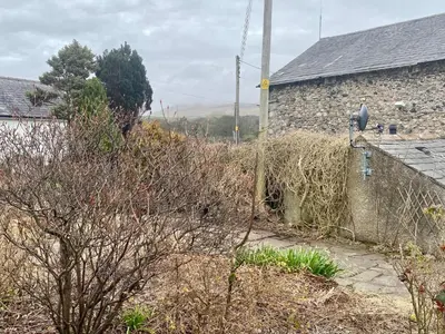 a house with a pile of hay next to a building at lake District cottage in Bootle