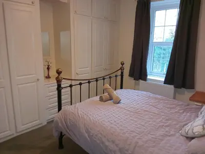 a teddy bear sitting on a bed in a bedroom at lake District cottage in Bootle