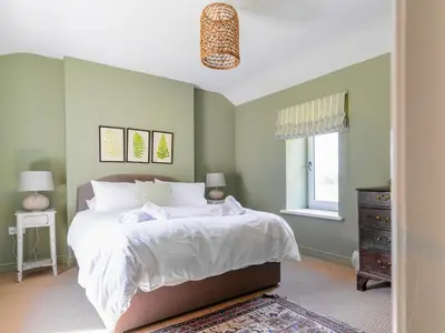 a bedroom with a large bed with green walls at Cleugh Foot in Longtown