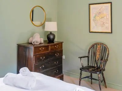 a bedroom with a dresser and a chair and a mirror at Cleugh Foot in Longtown