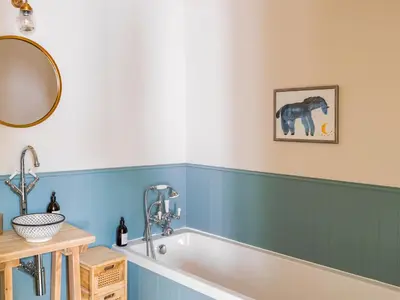 a bath tub in a bathroom with blue walls at Cleugh Foot in Longtown