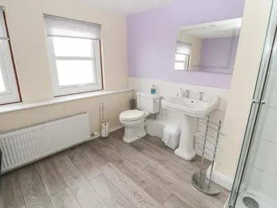 a bathroom with a toilet and a sink and a mirror at Cobbleken in Cockermouth