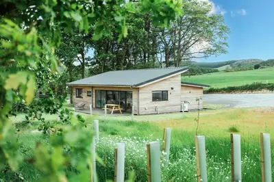 a small wooden cabin in the middle of a field at Ocean Drive in Gatehouse of Fleet