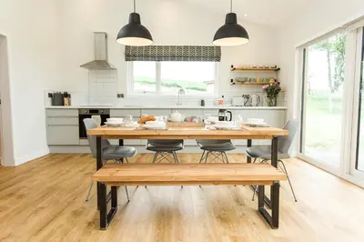 a kitchen and dining room with a wooden table and chairs at Ocean Drive in Gatehouse of Fleet