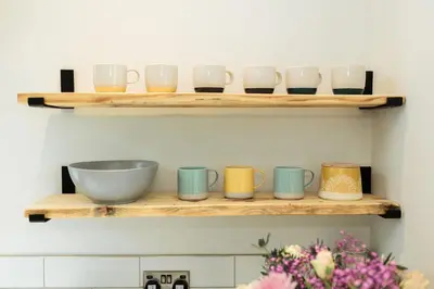 a shelf with bowls and cups on it at Ocean Drive in Gatehouse of Fleet