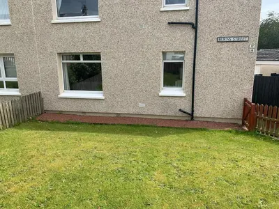 a building with a sign in front of a yard at 10 Burns Street, Tarbolton KA5 5RA in Tarbolton