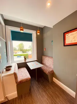 a small room with a table and a window at Luxury 2 bed apt 4 mins from M6 J44 pet friendly, in Carlisle