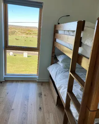 a bunk bed in a room with a window at New Town Hall Bunkhouse in Whithorn