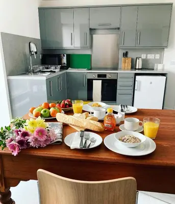 a kitchen with a table with food and fruit on it at New Town Hall Bunkhouse in Whithorn