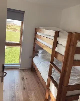 a bedroom with two bunk beds and a window at New Town Hall Bunkhouse in Whithorn