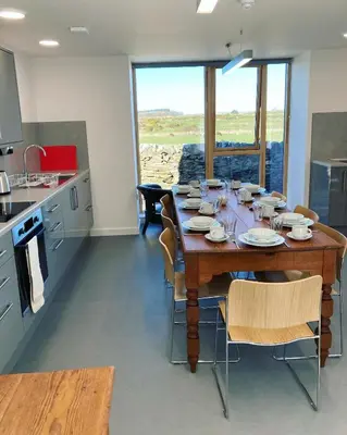 a kitchen with a wooden table and chairs in a room at New Town Hall Bunkhouse in Whithorn