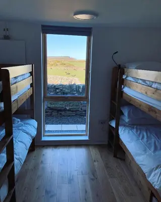 a room with two bunk beds and a window at New Town Hall Bunkhouse in Whithorn