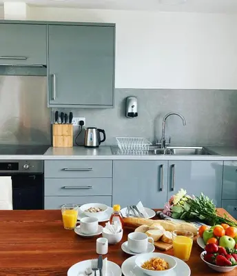 a kitchen with a table with plates of food on it at New Town Hall Bunkhouse in Whithorn