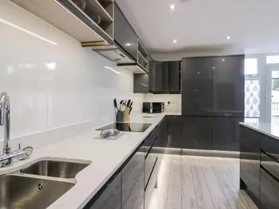 a kitchen with black and white cabinets and a sink at The Bay Tree in Penrith