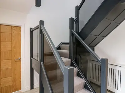 a staircase with glass railings in a house at The Bay Tree in Penrith