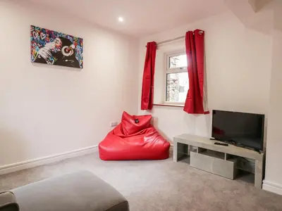 a living room with a red bean bag chair and a television at The Bay Tree in Penrith