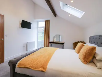 a bedroom with a large bed and a window at The Bay Tree in Penrith