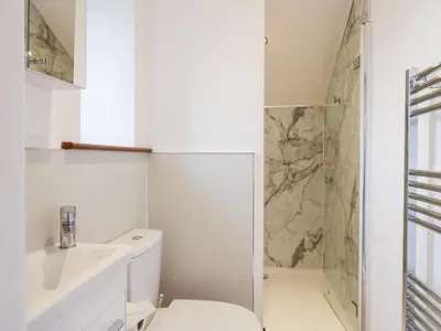 a white bathroom with a toilet and a shower at The Bay Tree in Penrith