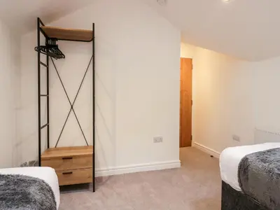a bedroom with two beds and a closet at The Bay Tree in Penrith