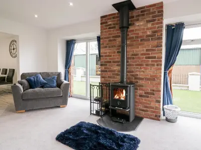 a living room with a brick wall and a fireplace at The Bay Tree in Penrith