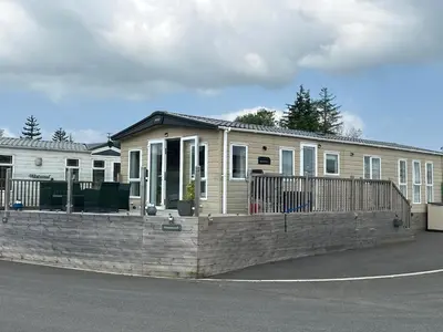 a house with a retaining wall in front of it at Luxury Lake District Holiday Lodge-Sleeps 4 in Cockermouth