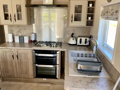 a kitchen with a stove and a sink at Luxury Lake District Holiday Lodge-Sleeps 4 in Cockermouth