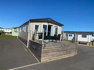 a tiny house with a wooden deck in a driveway at Luxury Lake District Holiday Lodge-Sleeps 4 in Cockermouth