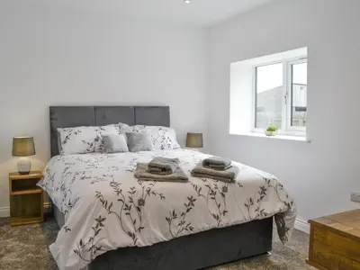 a bedroom with a large bed with two towels on it at Old Byre Cottage - Uk43377 in Kirklinton