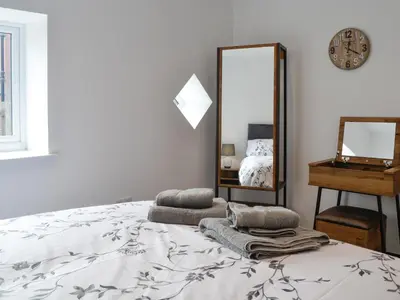 a bedroom with a bed and a mirror at Old Byre Cottage - Uk43377 in Kirklinton