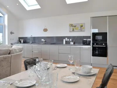 a table with plates and glasses on it in a kitchen at Old Byre Cottage - Uk43377 in Kirklinton