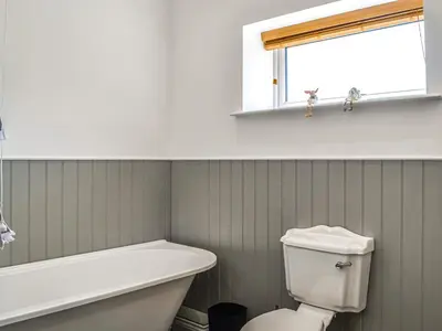 a bathroom with a tub and a toilet and a window at Fell View Cottage - Uk43378 in Kirklinton