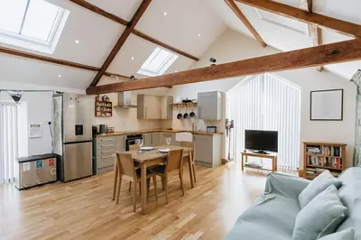 a kitchen and living room with a table and a couch at ELM HOUSE BARN - Converted One Bed Barn at the gateway to the Lake District National Park in High Hesket