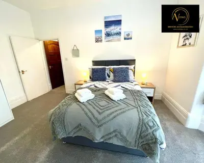 a bedroom with a large bed with towels on it at Three Bedroom in Seascale