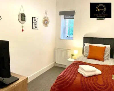 a bedroom with a bed and a tv and a window at Three Bedroom in Seascale