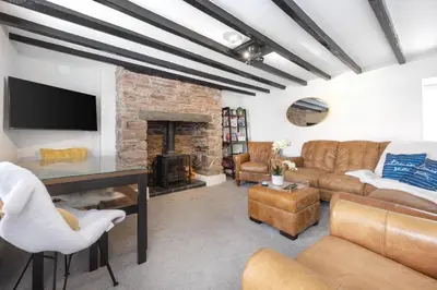 a living room with a couch and a fireplace at Hollie's Beach House in Peel