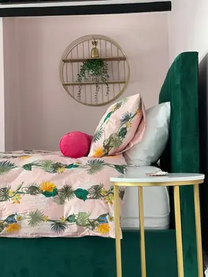 a bed with a pillow and a table at Hollie's Beach House in Peel
