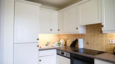 a kitchen with white cabinets and a sink at The Bridge in Kippford
