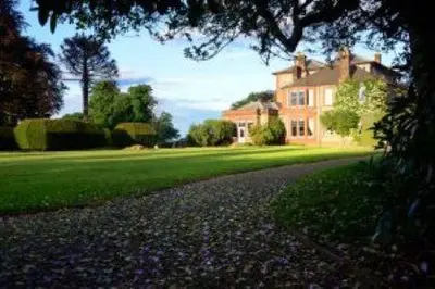 a house with a road in front of a house at Mabie House Hotel in Dumfries