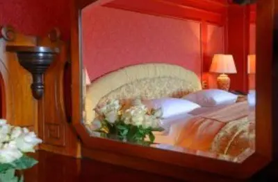 a reflection of a bedroom with a bed in a mirror at Mabie House Hotel in Dumfries