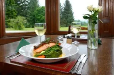 a plate of food on a table with wine glasses at Mabie House Hotel in Dumfries