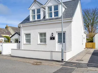 a white house on the side of a street at Crofthouse - Uk43405 in Wigtown