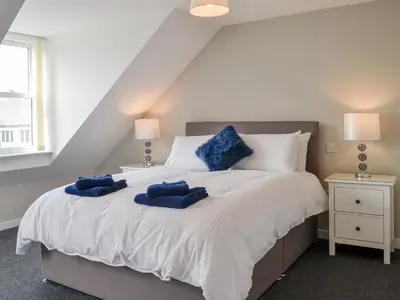 a bedroom with a bed with blue pillows on it at Crofthouse - Uk43405 in Wigtown