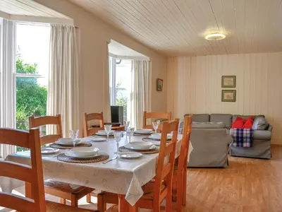a dining room with a table with chairs and a couch at Mossdale in Rockcliffe