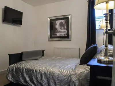 a bedroom with a bed and a desk and a television at Quayside7 in Whitehaven