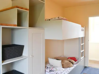 a bedroom with white bunk beds with a teddy bear at The Coach House in Blencogo