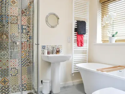 a bathroom with a tub and a sink and a shower at The Coach House in Blencogo