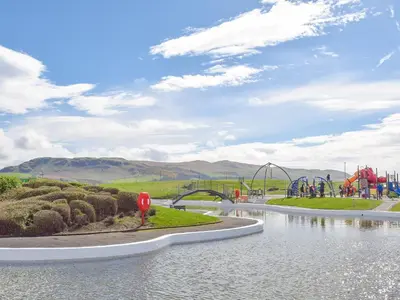 a water park with a roller coaster in the background at Miners Cottage in Girvan
